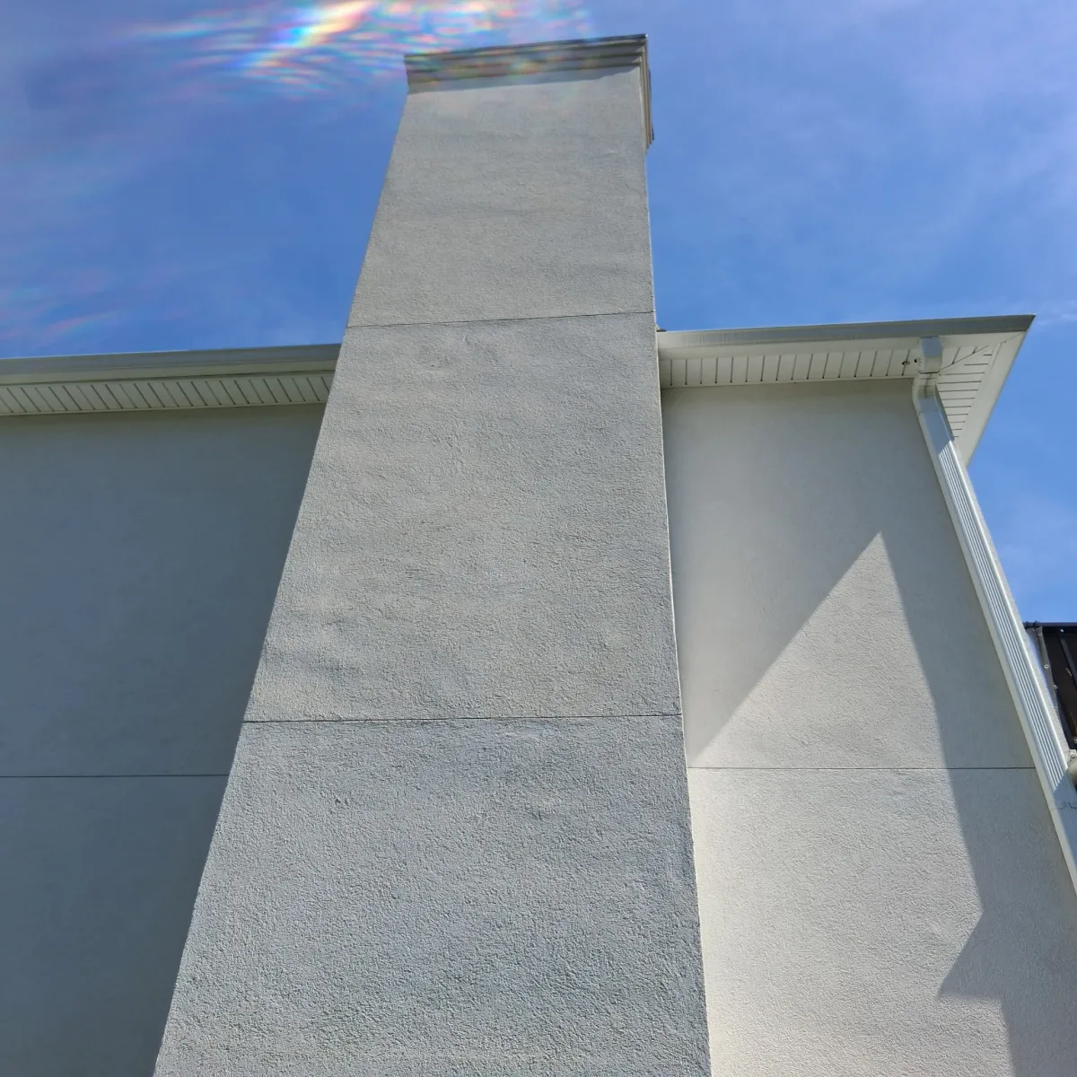 Stucco chimney after professional soft wash cleaning - pristine and restored