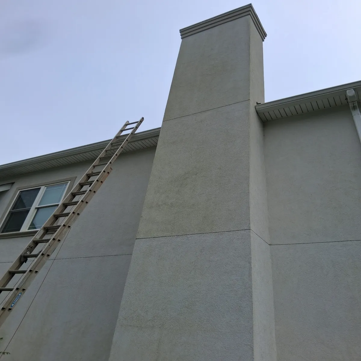 Stucco chimney before professional cleaning - showing algae and mold stains